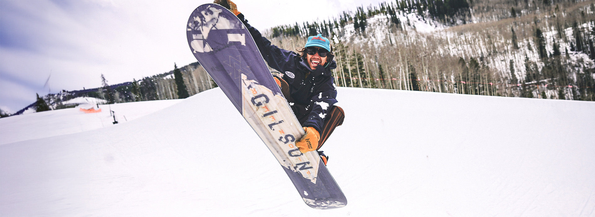 GILSON rider throwing a grab mid-air and grinning at the camera