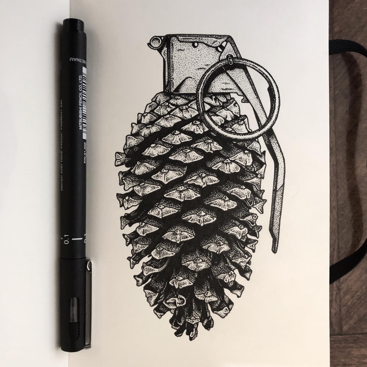 Original Pine Grenade ink drawing in the artist's sketchbook, pen beside it
